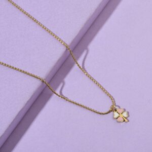 Gold rope chain necklace with pink and white enamel four leaf clover pendant on lilac background